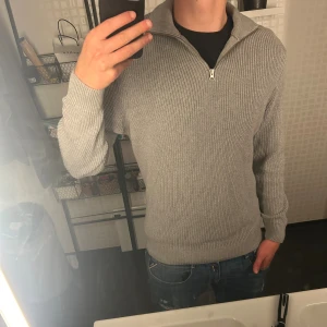 Grå stickad half zip-tröja från Zara - Säljer en grå stickad tröja från Zara med half zip-dragkedja och hög krage, Perfekt för lager-på-lager under kyliga dagar. Använt 1 gång