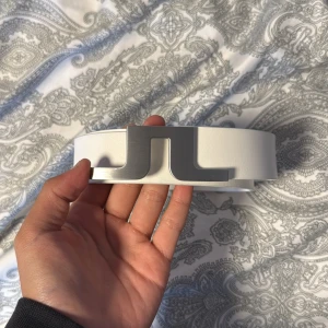 J.Lindeberg läderbälte - Tja! Säljer ett sjukts snygg J.Lindeberg bälte i färgen vit med silver buckla. Sjukt snyggt passar perfekt till vardag och fest tillomed när du ska golfa. Skick: 8/10 använd ett fåtal gånger fortfarande i fint skick ett eget hål är gjord. Storlek: 90cm. Pris: 400kr köpt för 700kr pris kan diskuteras vid snabb affär💨Kom DM vid fler bilder eller funderingar🥰
