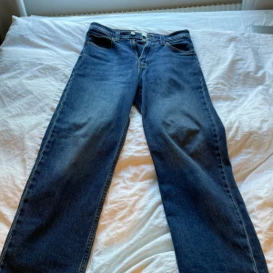 Baggy jeans från Hollister W28 L30 - Säljer ett par mörkblå baggy jeans från Hollister i klassisk denim. Jeansen har fem fickor, raka ben och en avslappnad passform. Perfekta för dig som gillar en loose och trendig stil. Tillverkade i bomull för skön känsla.