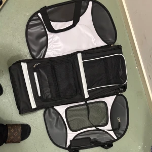 Svart och vit resväska med draghandtag - Stor och praktisk resväska i svart och vitt med draghandtag och flera fack med nät. Väskan har robusta handtag, dragkedjor och detaljer i syntetmaterial. Perfekt för att organisera packningen och enkel att rulla tack vare teleskophandtaget. Använd bara en gång för vår kattunge sen har den ja legat stilla