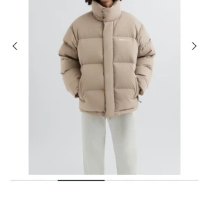 Beige pufferjacka från Axel arigato  - Säljer en beige pufferjacka från Axel arigato med hög krage och oversized passform. Jackan har stora quiltade partier, dragkedja och tryckknappar framtill samt diskret logga på bröstet. Perfekt för kalla dagar.