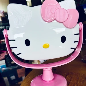 Söt sminkspegel med Hello Kitty-motiv! - Söt sminkspegel med Hello Kitty-motiv som kan vinklas 360 grader. Höjd: 20 cm. Bredd: 18 cm. Ny och oanvänd. Kommer i originalkartong. 