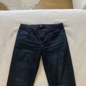 Mörkblå bootcut jeans från LTB W25 L32 - Snygga mörkblå jeans från LTB i modellen Valerie. Jeansen har klassisk femficksdesign, normal passform och bootcut-ben. Tillverkade i stretchigt denim för en bekväm känsla. Perfekta för dig som gillar en tidlös look med lite utsvängda ben.