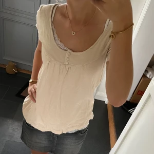 Beige stickad topp  - Beige topp med knappar från Ici et maintenant i fint skick. Står storlek 2 vilket betyder att den passar S/M. Använd gärna köp nu!
