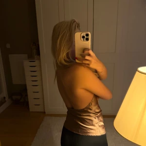 Bronsfärgad halterneck topp i satin - Säljer en snygg bronsfärgad halterneck topp i satin med öppen rygg från Zara i storlek S. Perfekt för festliga tillfällen och är knappt använd. 🤎