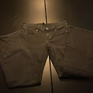Svarta jeans från H&M Divided - Svarta jeans från H&M Divided med klassisk femficksdesign och raka ben. Jeansen har flared och är tillverkade i bomullsmix med en lätt stretch. Perfekta till en avslappnad stil och funkar året runt.