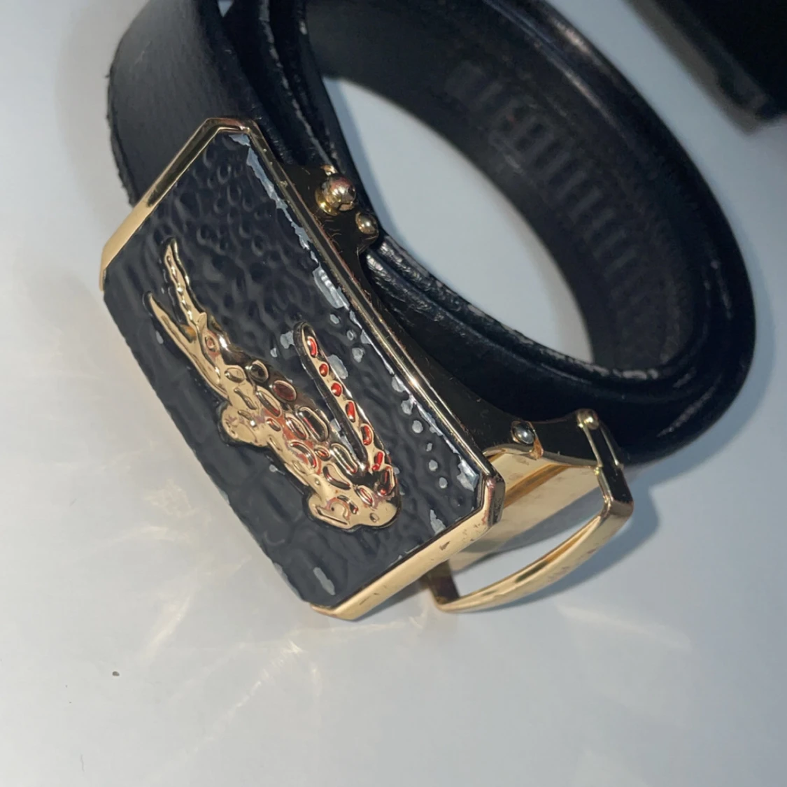 Svart bälte med guldspänne från lacoste