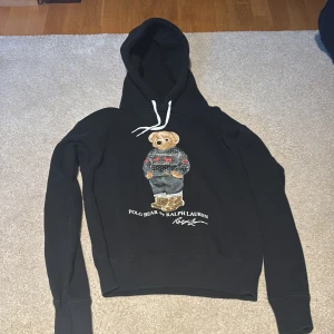 Svart hoodie Polo Bear Ralph Lauren - Svart hoodie från Polo Ralph Lauren med ikoniska Polo Bear-trycket på bröstet. Vid snabb affär kan priset diskuteras 