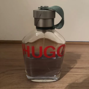Hugo boss Men Edt - Stilren parfym från Hugo Boss med tydlig röd logga och praktisk grön rem på korken. Perfekt för dig som vill ha en klassisk och modern accessoar i badrumsskåpet. Obs  flaskan är 125ml och ungefär 60ml kvar!!!