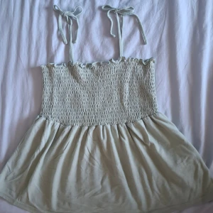 Ljusgrön kort klänning från Vero Moda - Ljusgrön topp från Vero Moda. Knappt använd. Skriv om ni vill ha andra bilder