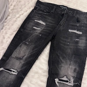 Svarta jeans Supply & Demand - Svarta jeans från Supply & Demand med slitna detaljer och trasiga partier på benen. Sitter perfekt och har en clean look 