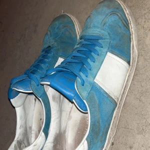Blå sneakers från Valentino - Snygga blå skor  från Valentino, skorna är i 76/10 skick, inga hål eller några defekter utom att mockan är lite blek och det fattas några nitar. Om du har några frågar så är de bara skriva mvh Elias