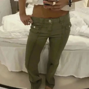 Olivgröna lågmidjade bootcut jeans hm - Snygga olivgröna jeans med låg midja och bootcut-ben ifrån H&M. Byxorna har framfickor med lock och synliga sömmar som ger en cool look. Passar dig som gillar en avslappnad och trendig stil.