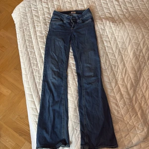 Blå bootcut jeans från Nelly, low waist - Snygga blå bootcut jeans från Nelly med låg midja. Jeansen har klassisk femficksdesign och är tillverkade i ett mjukt denimtyg som sitter skönt. Perfekta för dig som gillar en retroinspirerad look med utsvängda ben.