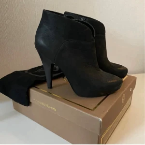 Svarta stövletter med klack från italienska ASH - Snygga svarta stövletter från italienska ASH med spetsig tå och hög klack. Skorna är tillverkade i skinn och har dragkedja på sidan för enkel på- och avtagning. Perfekt för dig som gillar stilrena och eleganta boots med lite edge. Skorna är använda max 2 ggr men finns lite märken.  Zooma in nosen och klacken. Mycket dyr inköp 