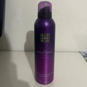 The Ritual of Yozakura duschgel - Lyxig duschgel i skumformat från Rituals, The Ritual of Yozakura. Flaskan är lila med svart och silverdetaljer och innehåller 200 ml. Doft av svart ris och yoshino körsbärsblom. Perfekt för en fräsch och mjuk känsla i duschen.