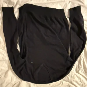 Svart stickad tröja från J.Lindeberg - Svart stickad tröja från J.Lindeberg med diskret logga på bröstet. Tröjan har långärmade smala ärmar och rund halsringning. Materialet är mjukt och passar perfekt för kyliga dagar. Enkel och stilren design som funkar till många olika looks.