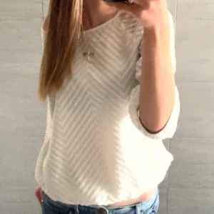 Vit blus med zigzag-mönster från Vero Moda - Säljer en vit blus från Vero Moda med snyggt zigzag-mönster i struktur. Blusen har rund halsringning och trekvartsärmar med resår vid ärmslut och nederkant. Materialet är mjukt och lätt, perfekt för dig som gillar stilrena detaljer.