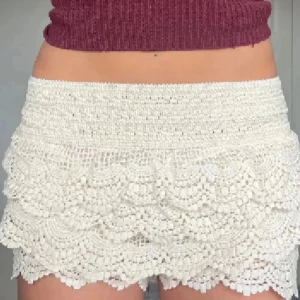 virkade spets-shorts - Superfina shorts med virkade spetsdetaljer och volangkant. De är högmidjade och har en elastisk midja som sitter bekvämt. Perfekta för sommarens varma dagar och ger en söt och bohemisk vibe. Aldrig använda