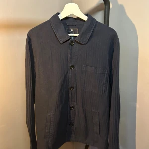 Mörkblå overshirt från Matinique - Snygg mörkblå overshirt från Matinique i bomull. Klassisk krage, knäppning framtill med svarta knappar och tre fickor. Perfekt lager-på-lager-plagg med enkel, stilren design och lång ärm. Nypris: 1300kr