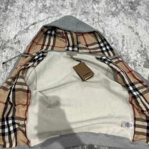 Grå hoodiejacka från Burberry - Helt ny grå kofta från burberry med tag och i mycket bra skick 