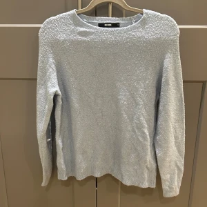 Ljusblå stickad tröja från Bik Bok - Supermysig ljusblå stickad tröja från Bik Bok i storlek S. Tröjan har en enkel design med rund halsringning och långa ärmar. Materialet är fluffigt och ger en soft känsla, perfekt för kyliga dagar.