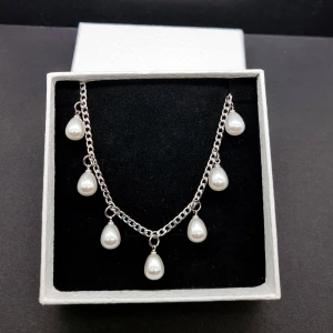 Stilfullt halsband  - Stilfull halskedja med pärlor.                                Material: rostfrit stål                                                                   Längd: 40-45 cm..Nickelfri .Priset utan ask blir lägre.