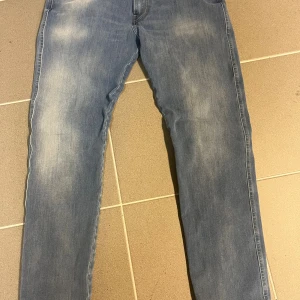 Replay ljusblå jeans, midwaist, 33/32 - Säljer ett par ljusblå jeans från Replay i klassisk femficksmodell. Jeansen har raka ben, snygga färger och kontrastsömmar på bakfickorna. Skön passform med midwaist och tillverkade i mjukt denimtyg. Perfekta för en avslappnad stil.