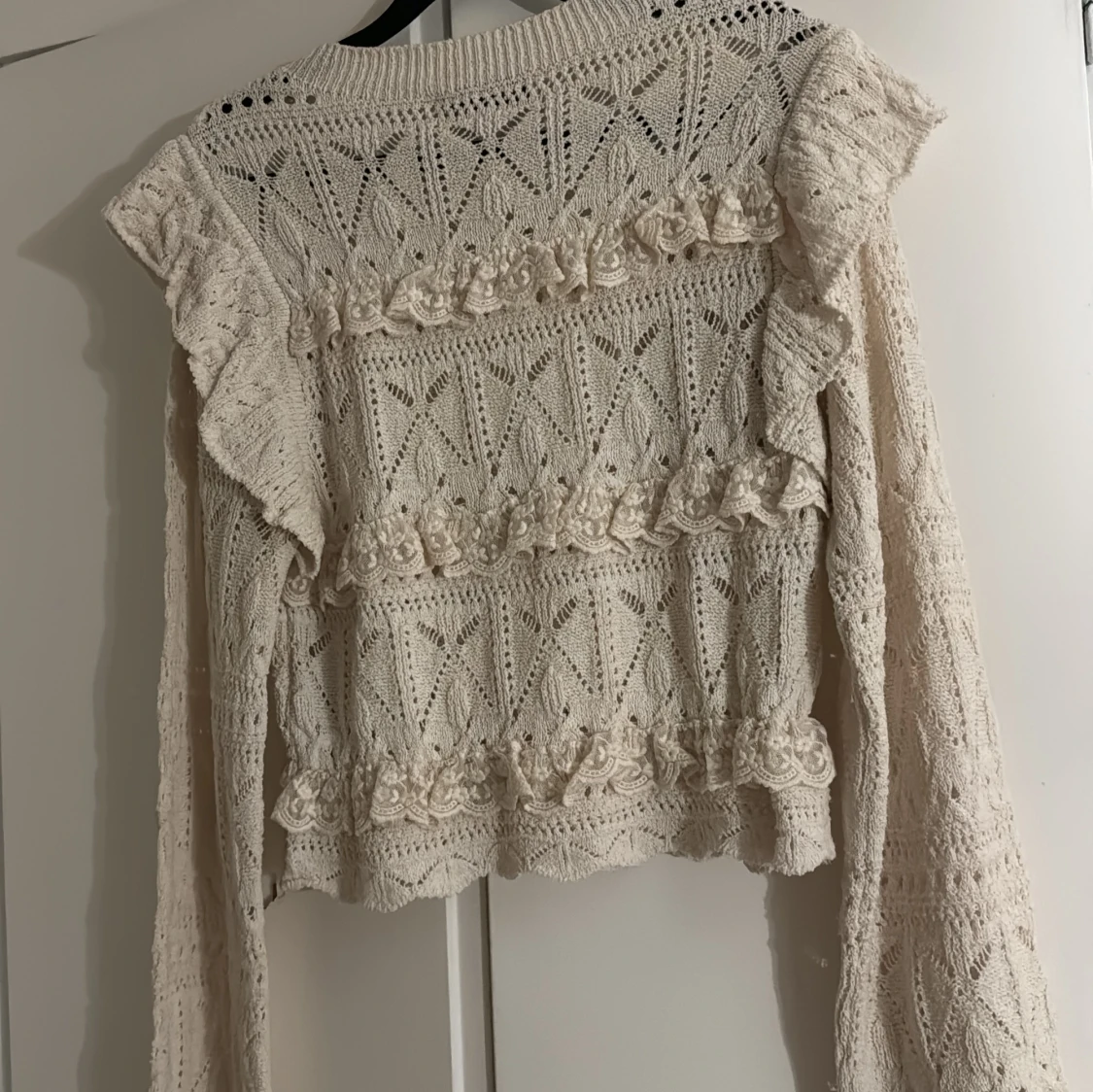 Beige stickad tröja med volanger - 1