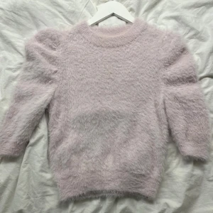 Ljusrosa fluffig stickad tröja VRS - Supermysig ljusrosa stickad tröja från VRS Woman i storlek XS. Tröjan har fluffig yta, puffade axlar och rund halsringning. Perfekt för dig som gillar mjuka och gosiga plagg med lite extra volym på axlarna.passar även s 