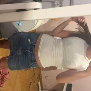 Blå jeanskjol med fransig kant från ZARA  - Säljer en snygg blå jeanskjol med rå, fransig nederkant och klassiska fickor fram och bak. Kjolen har dragkedja och knapp framtill och är i en kort modell som sitter snyggt på höften. Perfekt för dig som gillar en avslappnad och trendig stil.