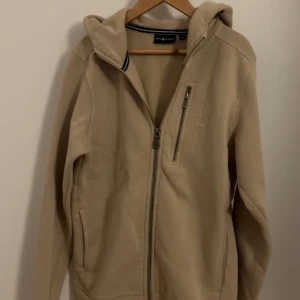 Sail Racing hoodie - Beige hoodie från sail racing. Väldigt bra skick och nypriset är 1100. Köpt från kidsbrandstore. Endast en liten fläck vid armhålan typ som knappt syns. Hör av er om mer frågor! Priset är såklart inte hugget i sten