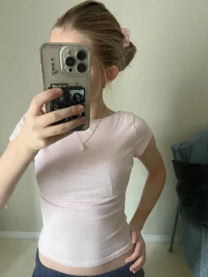 Ljusrosa topp med öppen rygg.  - Supersöt ljusrosa topp från H&M i storlek XS. Toppen har korta ärmar och en rundad halsringning, perfekt för dig som gillar en enkel och clean look. Materialet är mjukt och stretchigt bomull som sitter skönt mot kroppen. Den är öppen i ryggen. 