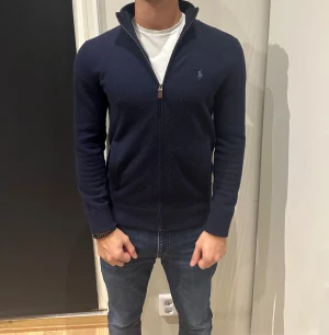 Marinblå kofta från Ralph Lauren - Snygg marinblå kofta från Ralph Lauren med dragkedja och ståkrage. Jättebra skick. Storlek XS men passar S. Ny kostar den 2700 på Zalando. Finns scan på den. Mitt pris 999kr 