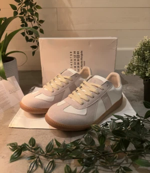 Vita Maison Margiela skor - Säljer mina Maison Margiela skor. Dem är nästan helt nya, finns knappt några tecken på användning. Nypris på Maison Margiela skor är ca 7000 kr. Anledning varför jag säljer skorna är pågrund av att de är en storlek för små för mig och går inte att lämna tillbaks. Skorna är i storlek 41 är och är i nyskick. Box och dustbag ingår. Skriv om du vill ha fler bilder eller ha några generella frågor! Inga frågor är dumma. 😊👍