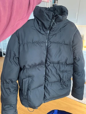 Svart pufferjacka med hög krage - Svart pufferjacka med hög krage, vadderad. 