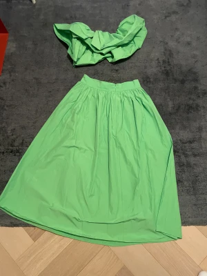 Grön långkjol från H&M - Snygg grön långkjol från H&M i luftig bomull. Kjolen har hög midja, bred linning och fina veck som ger volym. Perfekt för dig som vill sticka ut med en poppig färg och flowig siluett.