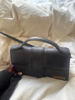 Svart handväska från Jacquemus - Säljer nu min superfina väska från Jacquemus då den tyvärr inte kommer till användning, nyskick då den endast är använd vi två tillfällen, har sålt min dustbag därav priset, nypris 10 000, bara att skriva för fler frågor!! Kvitto finns