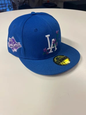Blå LA keps - Blå LA keps, helt ny. Säljer då den hade fel passform och returen policyn hade gått ut. Strl 56,6cm. Fraktas enbart. 250kr