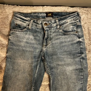 Blå bootcut jeans från Lee - Snygga blå jeans från Lee med bootcut passform och slitna detaljer vid knäna.        XS/S