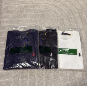 Polo Ralph Lauren t-shirt, olika färger - Storlek L men slimfit så passar M Snygga t-shirts från Polo Ralph Lauren med klassisk logga på bröstet. Finns i marinblått med röd logga, svart med vit logga och vitt med svart logga. Alla har rund hals och korta ärmar, tillverkade i mjuk bomull. Perfekt för dig som gillar stilren och ikonisk design.