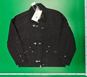 Svart overshirt med metalldetaljer - Svart overshirt med coola metalldetaljer och dragkedjor på fickorna. Jackan har klassisk krage, knappar vid ärmslut och flera spännen framtill. Oversized passform och tillverkad i bomull. Perfekt för dig som gillar streetstyle och vill sticka ut.