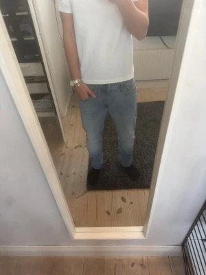 Ljusblå jeans från Jack & Jones - Säljer ett par ljusblå jeans från Jack & Jones med klassisk femficksmodell och normal passform. Nypris ca 900 och är inte andvända mycket alls. Modellen heter Clark 30 30 ungefär