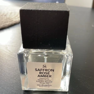 Saffron Rose Amber 30ml från TryScent - Parfymflaska i glas med svart fyrkantigt lock. Doften heter Saffron Rose Amber och är inspirerad av Maison Francis Kurkdjian Baccarat Rouge 540. Flaskan rymmer 30 ml och har en stilren, modern design med tydlig etikett framtill. Endast ett sprut testat!