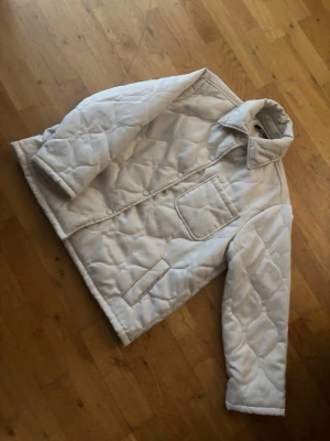 Vit quiltad pufferjacka Gina Tricot - Säljer en vit quiltad pufferjacka från Gina Tricot. Jackan har tryckknappar framtill, två fickor och en bröstficka. Oversized krage och mjukt, vadderat material som håller dig varm. Perfekt för kalla dagar och riktigt snygg till alla outfits.