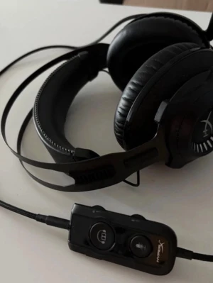 HyperX gaming headset med mikrofon - Säljer ett par svarta over-ear gaminghörlurar från HyperX med inbyggd mikrofon och kontrollenhet på sladden. Hörlurarna har mjuka öronkuddar i konstläder och justerbart huvudband i metall och plast. Perfekta för gaming och voicechat.
