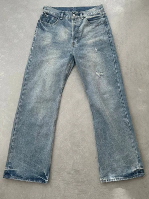 Acne studios Blå raka jeans - Säljer ett par blå jeans från acne studios med rak passform och lätt slitna detaljer på framsidan. Jeansen har klassisk femficksdesign, knappgylf och ljus tvätt. Perfekta för en avslappnad och trendig look. Köpt begangnat för någon månad sedan. Endast använd några få gånger. Väldigt bra skick. 