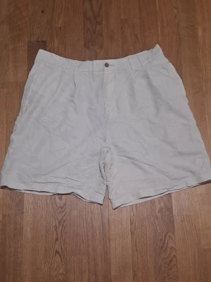 Vita shorts med fickor - Säljer vita shorts från Breakwater med normal passform. Shortsen har sidofickor fram och två bakfickor med knappdetalj. 