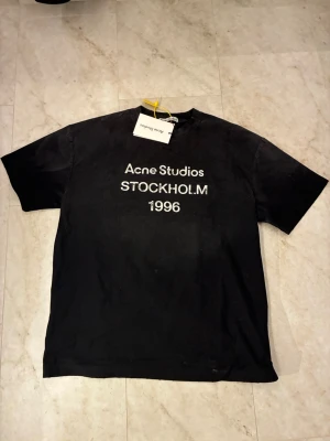 Svart Acne Studios t-shirt  - Svart t-shirt från Acne Studios med tvättad design. Tröjan är i helt nytt skick och är i storleken M.  Taggar och allt fins kvar och har inga defekter. Hör av er vid frågor!