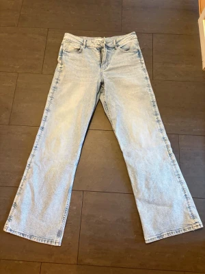 Ljusblåa raka jeans med hög midja - Säljer ett par ljusblå jeans med rak passform och hög midja. De är köpta från gina tricot men kommer inte till användning. Använda ca 2 gånger. Storlek 40, kan skicka mer bilder vid intresse! 
